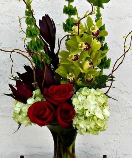 Island Time embraces the textures and shapes that can only be found when island bound. This vase arrangement brings together of hydrangea, roses, Bells of Ireland, Cymbidium Orchids and other tropical flowers. 